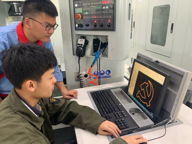 圖為黨員青年教師高飛正指導學生用數控車床制作黨徽 學校供圖.jpg 圖為黨員青年教師高飛正指導學生用數控車床制作黨徽 學校供圖.jpg