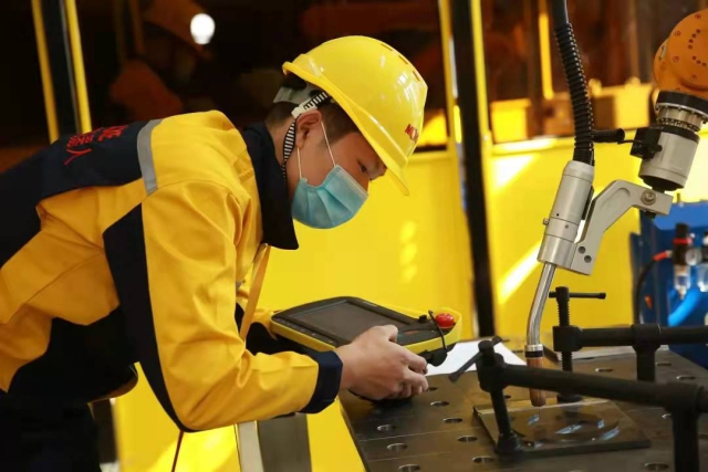 圖為學生正在用焊接機器人對設計稿進行雕刻 學校供圖.jpg 圖為學生正在用焊接機器人對設計稿進行雕刻 學校供圖.jpg