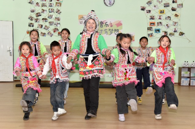 馬游小學社團課上，梅葛文化國家級傳承人羅英老師教學生邊唱娃娃梅葛調邊跳彝族舞蹈。（蔡興華  攝影）.JPG