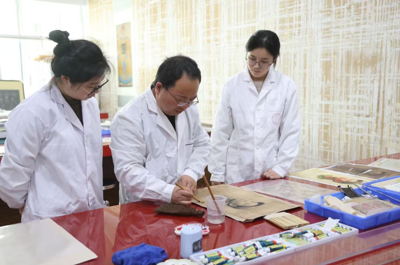 寧波財(cái)經(jīng)學(xué)院“我為烈士修遺物”師生團(tuán)隊(duì)正在修復(fù)烈士畫(huà)像 張培堅(jiān) 攝.jpg